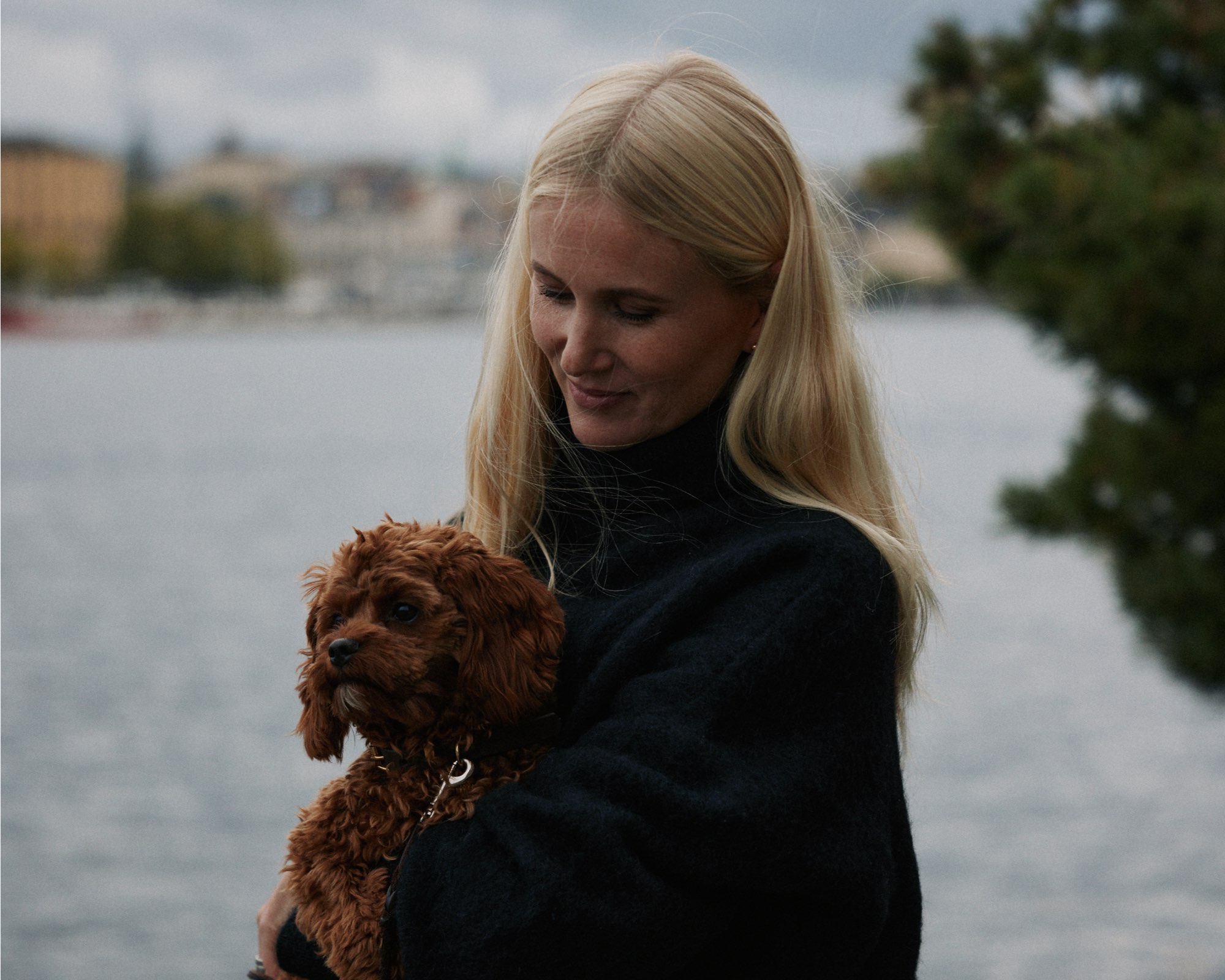 Olivia som håller Rufus intill vatten